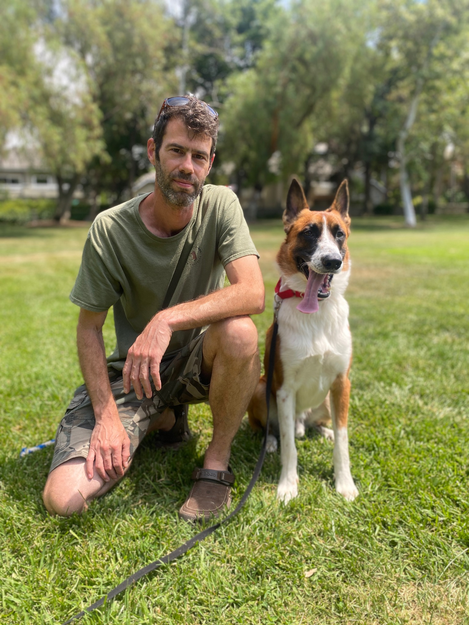 Raam kneeling beside a dog after an outdoor training session