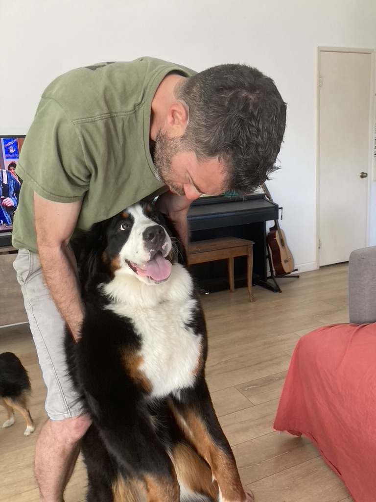 Raam sharing an affectionate moment with a dog in his home